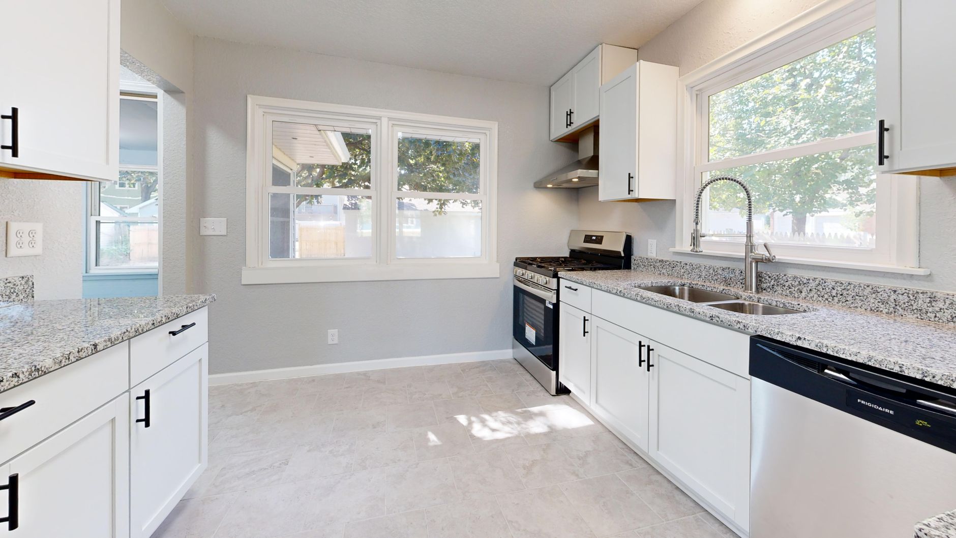 Stock photo of sunlit modern kitchen featuring granite countertops and sleek white cabinetry for kitchen remodeling O'Fallon IL guidance