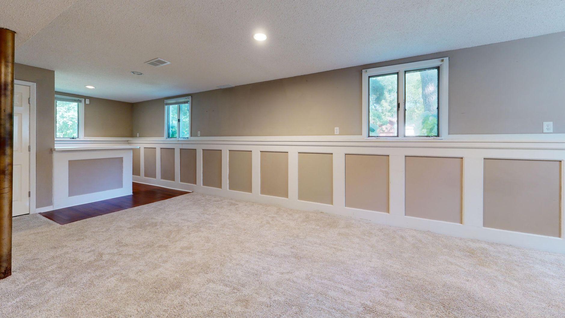 finished basement with white baseboards, window casing, chair rail, and paneled trim for trim work Waterloo IL guidance